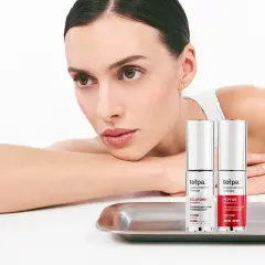 Kobieta z dwoma produktami Tołpa Estetic na tacy.